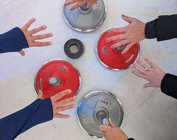 Hände über Eisstock